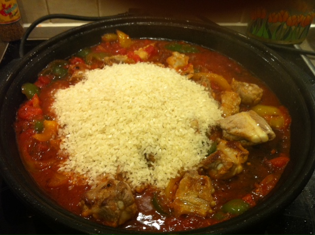 adding rice to paella